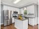Modern kitchen with stainless steel appliances, kitchen island, and white cabinets at 1008 Brittley Way, Apex, NC 27502