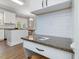 Kitchen desk area featuring granite countertop, white cabinetry, and subway tile backsplash at 1008 Brittley Way, Apex, NC 27502
