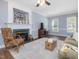 Comfortable living room with fireplace, ceiling fan, and natural light from large windows at 1008 Brittley Way, Apex, NC 27502