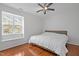 Bedroom features a ceiling fan, large window, and wood flooring at 102 Choptank Ct # B5, Cary, NC 27513
