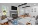 Bright living room features a stone fireplace, TV, a blue rug and hardwood flooring at 102 Choptank Ct # B5, Cary, NC 27513
