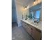 Bright bathroom features double vanity, stone countertops, modern fixtures, and hexagon tile flooring at 1029 Azalea Garden Cir, Raleigh, NC 27603