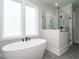 Modern bathroom with a standalone tub, a glass-enclosed shower, and sleek black fixtures at 1029 Azalea Garden Cir, Raleigh, NC 27603