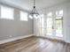 Dining room with wood flooring, a modern chandelier, and doors that lead to an outdoor space at 1029 Azalea Garden Cir, Raleigh, NC 27603