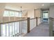 Upstairs hallway featuring a stylish chandelier, carpet flooring, and abundant natural light at 1029 Azalea Garden Cir, Raleigh, NC 27603