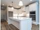 Bright kitchen features white cabinets, a large island, stainless appliances, and stylish pendant lighting at 1029 Azalea Garden Cir, Raleigh, NC 27603