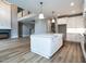 Open concept kitchen with an island and stainless sink, flowing into the living space with a fireplace at 1029 Azalea Garden Cir, Raleigh, NC 27603