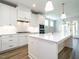 Gourmet kitchen with white cabinets, pendant lighting, and an oversized island with stone countertops at 1029 Azalea Garden Cir, Raleigh, NC 27603