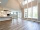 Open-concept living area featuring high ceilings, a kitchen, and a wall of windows at 1029 Azalea Garden Cir, Raleigh, NC 27603