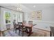 Dining room with vaulted ceiling, hardwood table and chairs, and natural light from large windows at 1039 S Philwood Ct, Fuquay Varina, NC 27526