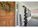 Inviting front porch featuring a wooden door, decorative wreath, and a curated welcome display at 1039 S Philwood Ct, Fuquay Varina, NC 27526