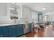 Modern kitchen featuring white cabinets, blue lower cabinets, quartz countertops, and stainless steel appliances at 1039 S Philwood Ct, Fuquay Varina, NC 27526
