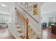 Elegant staircase with carpeted steps, wooden handrail, and gallery wall leading to the upper level at 1039 S Philwood Ct, Fuquay Varina, NC 27526