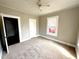 Bedroom with a ceiling fan, neutral colored walls, fresh carpet, and a bright window at 111 113 Highland Ave, Burlington, NC 27217