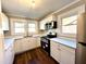 Modern kitchen with stainless steel appliances, white cabinets, and natural light from windows at 111 113 Highland Ave, Burlington, NC 27217