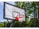 Outdoor basketball hoop with red rim and net. Surrounded by lush greenery and blue skies, this area is perfect for recreation at 1140 Sun Springs Rd, Wake Forest, NC 27587