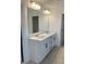 Bathroom with dual sinks, white cabinets, modern fixtures, and a large mirror providing a functional space at 1140 Sun Springs Rd, Wake Forest, NC 27587