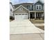 Two-story home featuring a spacious garage, manicured lawn, and a blend of siding and brick accents at 1140 Sun Springs Rd, Wake Forest, NC 27587