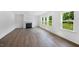 Bright living room featuring a fireplace, hardwood floors, and large windows overlooking the yard at 1140 Sun Springs Rd, Wake Forest, NC 27587