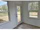 Bright sunroom featuring hardwood floors, many windows, and a glass door leading to a peaceful outdoor area at 1140 Sun Springs Rd, Wake Forest, NC 27587