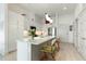 Bright kitchen with stylish white cabinetry, modern appliances, and a center island with seating overlooking the open living space at 120 Mosaic Blvd # 308, Pittsboro, NC 27312