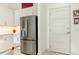 Modern kitchen featuring stainless steel refrigerator and white cabinets with adjacent doorway at 120 Mosaic Blvd # 308, Pittsboro, NC 27312