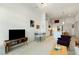 Open-concept living area with views of the kitchen, light wood floors, and comfortable modern furnishings at 120 Mosaic Blvd # 308, Pittsboro, NC 27312