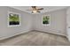Bright bedroom with neutral walls, ceiling fan, and natural light from two windows at 122 Monticello Ave, Durham, NC 27707