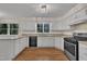 Bright kitchen featuring white cabinets, granite countertops, and modern appliances, ideal for culinary enthusiasts at 122 Monticello Ave, Durham, NC 27707