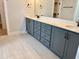 Bathroom vanity with double sinks, quartz countertop, and blue cabinets at 1237 Porters Call Dr, Wendell, NC 27591