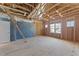 Under construction room has exposed wood beams, plywood flooring, and windows to the outside at 1237 Porters Call Dr, Wendell, NC 27591