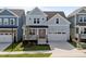 Charming two-story home with light blue siding, a welcoming front porch, and a two-car garage at 1237 Porters Call Dr, Wendell, NC 27591