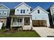 Charming two-story home with light blue siding, front porch, a two-car garage and landscaped front yard at 1237 Porters Call Dr, Wendell, NC 27591