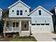 Charming two-story home with pale blue siding, white trim, a pink front door and attached two-car garage at 1237 Porters Call Dr, Wendell, NC 27591