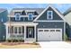 Charming two-story home with a well-manicured lawn and inviting front porch and a two car garage at 1237 Porters Call Dr, Wendell, NC 27591