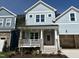 Beautiful two-story home with light blue siding, front porch, and manicured front yard under a clear blue sky at 1237 Porters Call Dr, Wendell, NC 27591