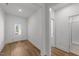 Bright hallway with light wood floors leading to the front door and a glimpse of the bathroom at 1237 Porters Call Dr, Wendell, NC 27591