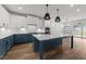 Spacious kitchen features white cabinets, blue island, modern light fixtures, and stainless steel appliances at 1237 Porters Call Dr, Wendell, NC 27591