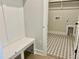 Mudroom with bench and hooks leading to laundry room with decorative floor tile at 1237 Porters Call Dr, Wendell, NC 27591