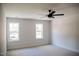 Spacious bedroom featuring plush carpet, ceiling fan, and two bright windows at 1326 Apache Ln, Apex, NC 27502