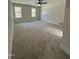 Expansive bedroom featuring plush carpet, ceiling fan, and two bright windows at 1326 Apache Ln, Apex, NC 27502