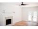 Bright living room featuring a brick fireplace, hardwood floors, and double doors to the outside at 1326 Apache Ln, Apex, NC 27502