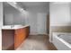 Bathroom featuring double sinks, a large mirror, soaking tub, and tiled floors for a clean modern look at 1412 Wesser Ct, Fuquay Varina, NC 27526