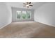 Spacious bedroom with neutral carpet, ceiling fan, and three large windows offering ample natural light at 1412 Wesser Ct, Fuquay Varina, NC 27526