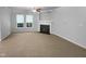 A spacious living room with neutral walls, carpet, a fireplace, and large windows offering natural light at 1412 Wesser Ct, Fuquay Varina, NC 27526