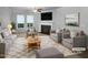 Bright living room featuring a cozy fireplace, plush seating, and natural light from large windows at 1412 Wesser Ct, Fuquay Varina, NC 27526