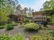 Expansive backyard with mature landscaping, stone pathways, screened in porch and pergola at 1604 Meadow Ln, Chapel Hill, NC 27516