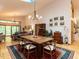 Dining room with rustic table, modern light fixture, hardwood floors, and view of the living room at 1604 Meadow Ln, Chapel Hill, NC 27516