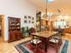 Open dining room with hardwood floors, built-in cabinet, and adjacent kitchen at 1604 Meadow Ln, Chapel Hill, NC 27516