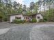 Charming single-story home featuring stone accents, gravel driveway, and lush landscaping at 1604 Meadow Ln, Chapel Hill, NC 27516